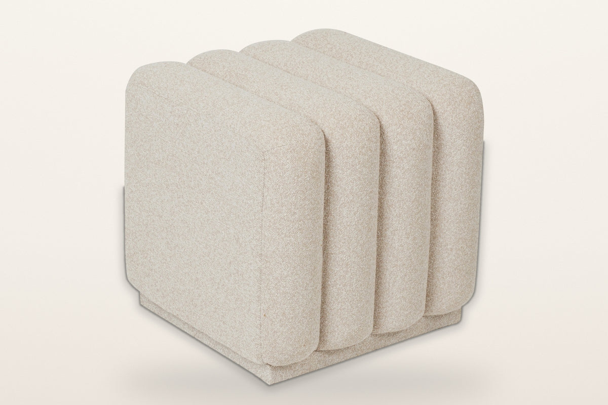 Abbadia channel-tufted square ottoman in oat, three-quarter view on a warm white studio backdrop