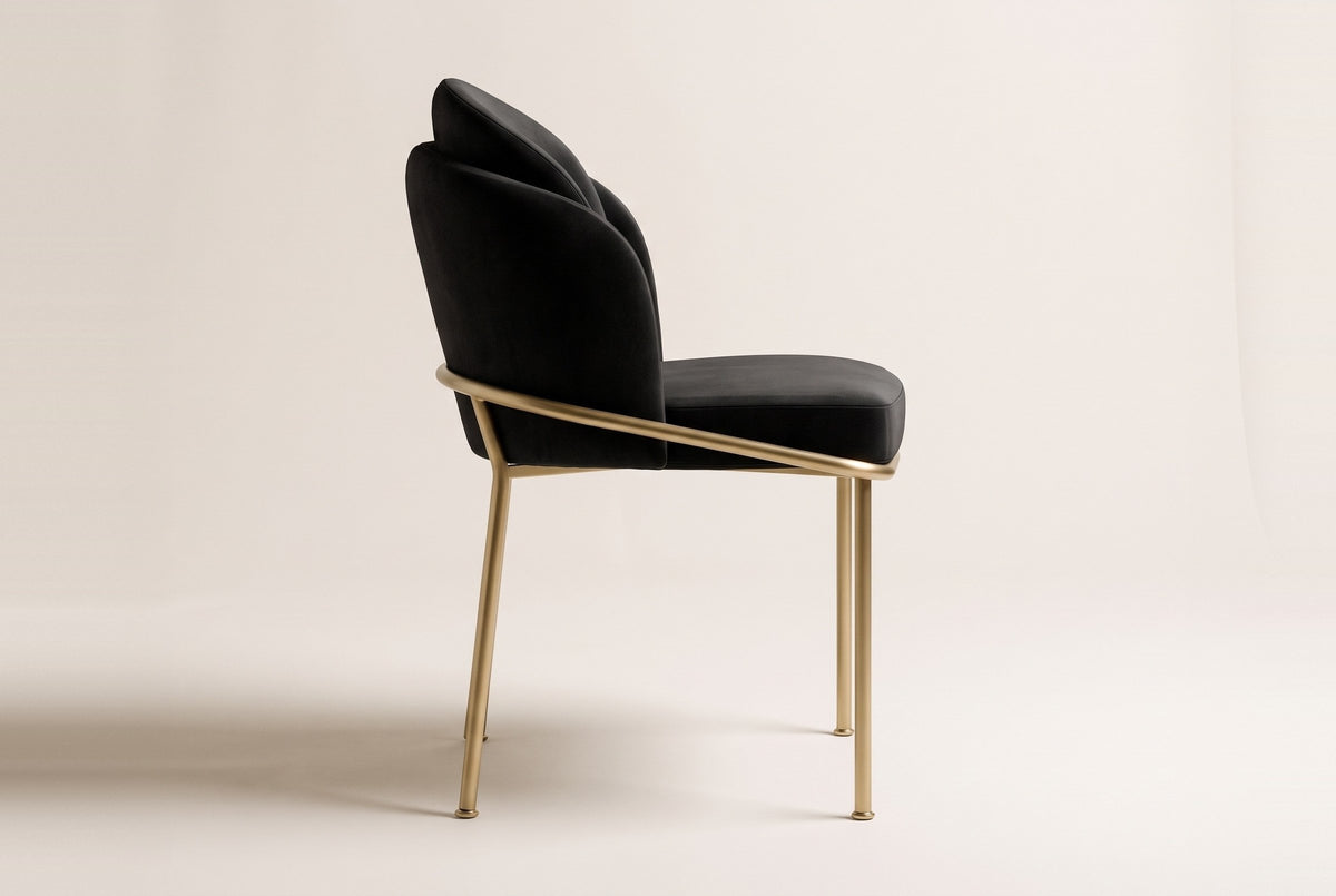 Alexander black velvet dining chair with brass legs in side view on an off-white studio backdrop