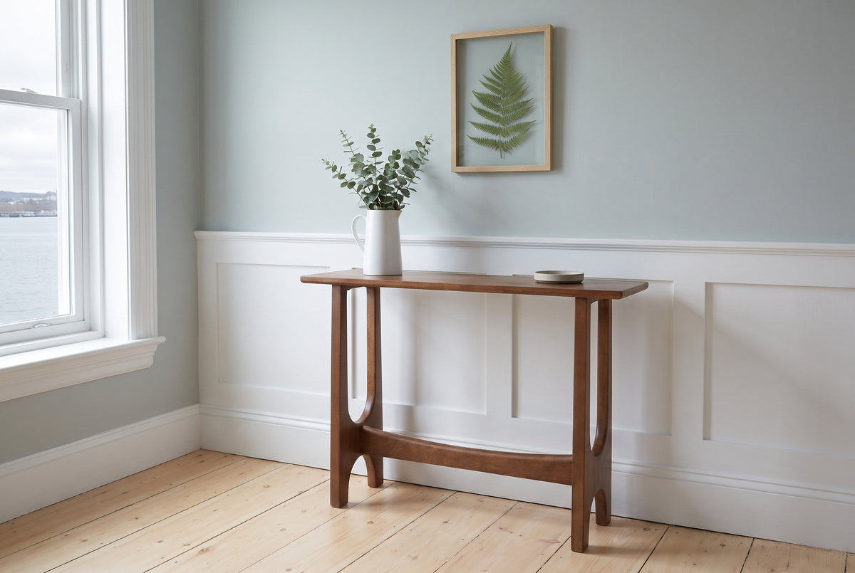 Amelia console table in walnut against a pale grey-blue wall above white wainscot in a Halifax row house front hall