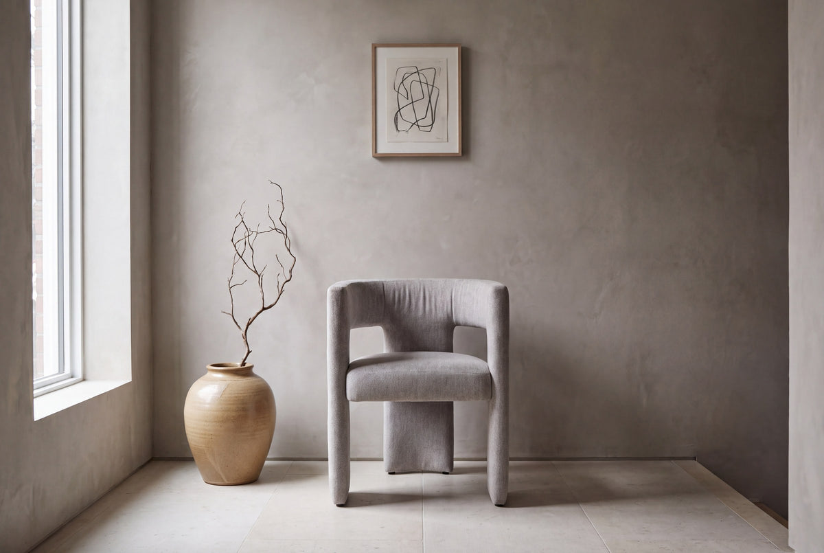 Andrea dining chair against a warm grey plaster wall in a gallery hallway