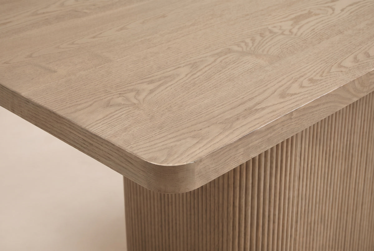 Close-up of the Aquileia tabletop corner in Natural: a thick edge, a soft rounded corner and open oak grain