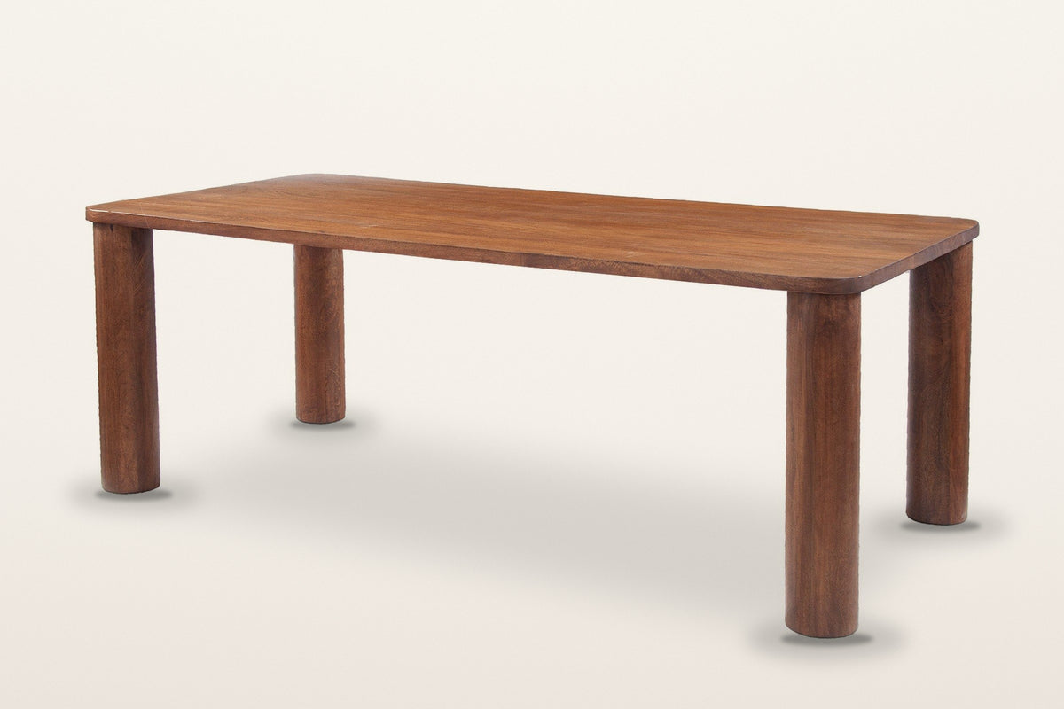 Arcevia solid mango dining table in Brown, three-quarter view on a warm white studio backdrop