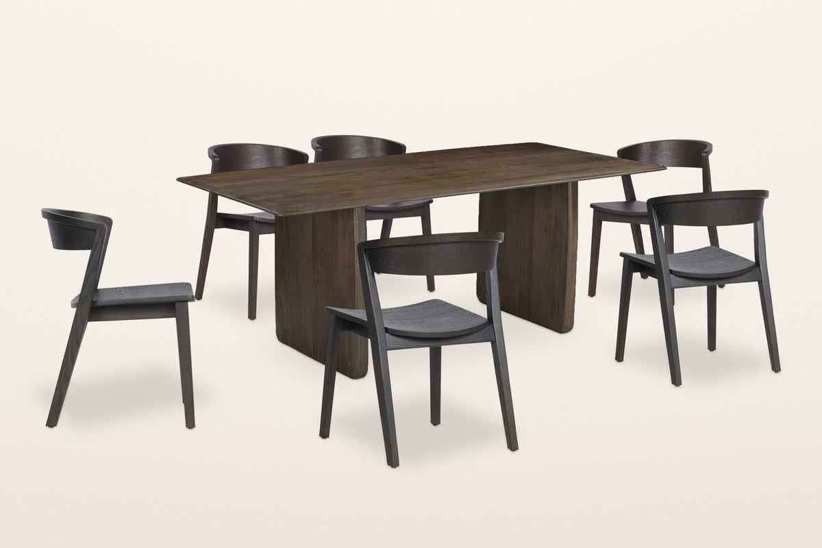 Arquata 7-piece dining set in mocha, three-quarter view on a warm white studio backdrop: the slab-leg mango wood table with six curved-back wood chairs