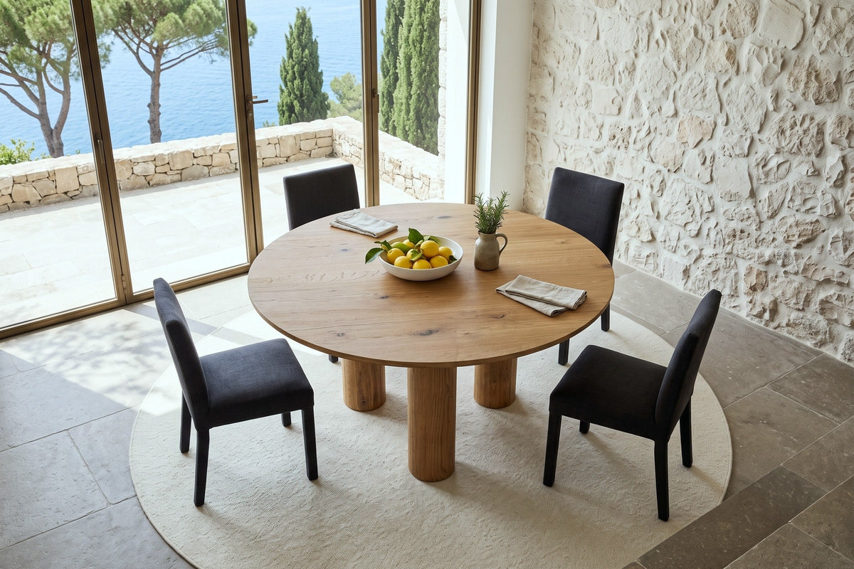Atzara round dining table seen from above in a cliff-top villa in Anacapri, with glass doors to a stone terrace