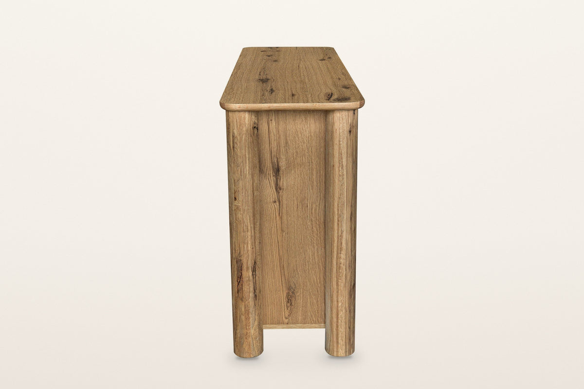 Atzara sideboard in Natural, end view on a warm white studio backdrop: a flat oak end panel between two round column posts