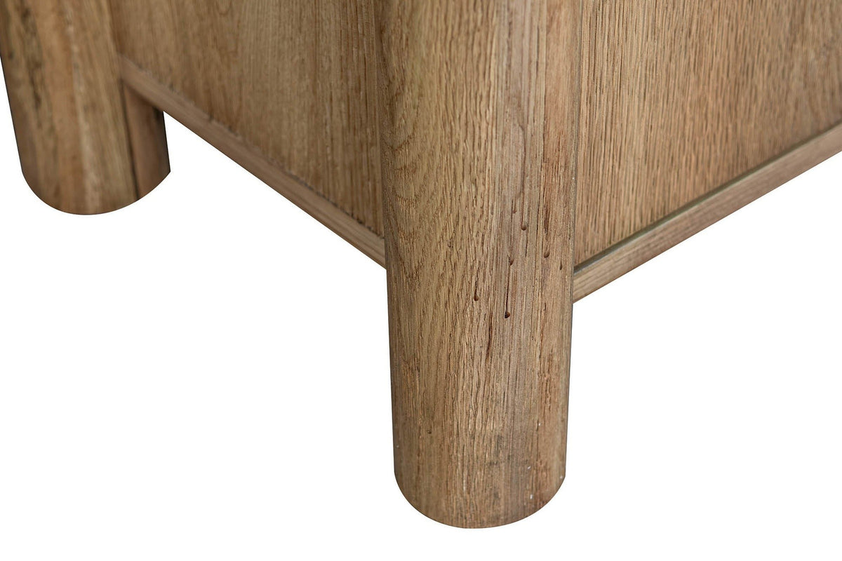 Close-up of two round column posts of the Atzara Small sideboard in Natural, standing on flat feet below the case