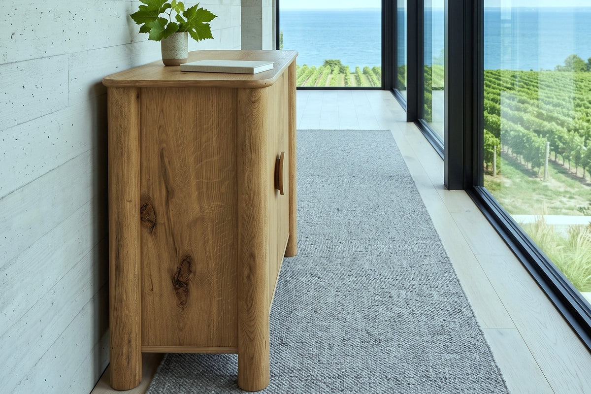 Atzara Small sideboard in Natural seen from the end in a hallway in a Grimsby house, with a board-formed concrete wall
