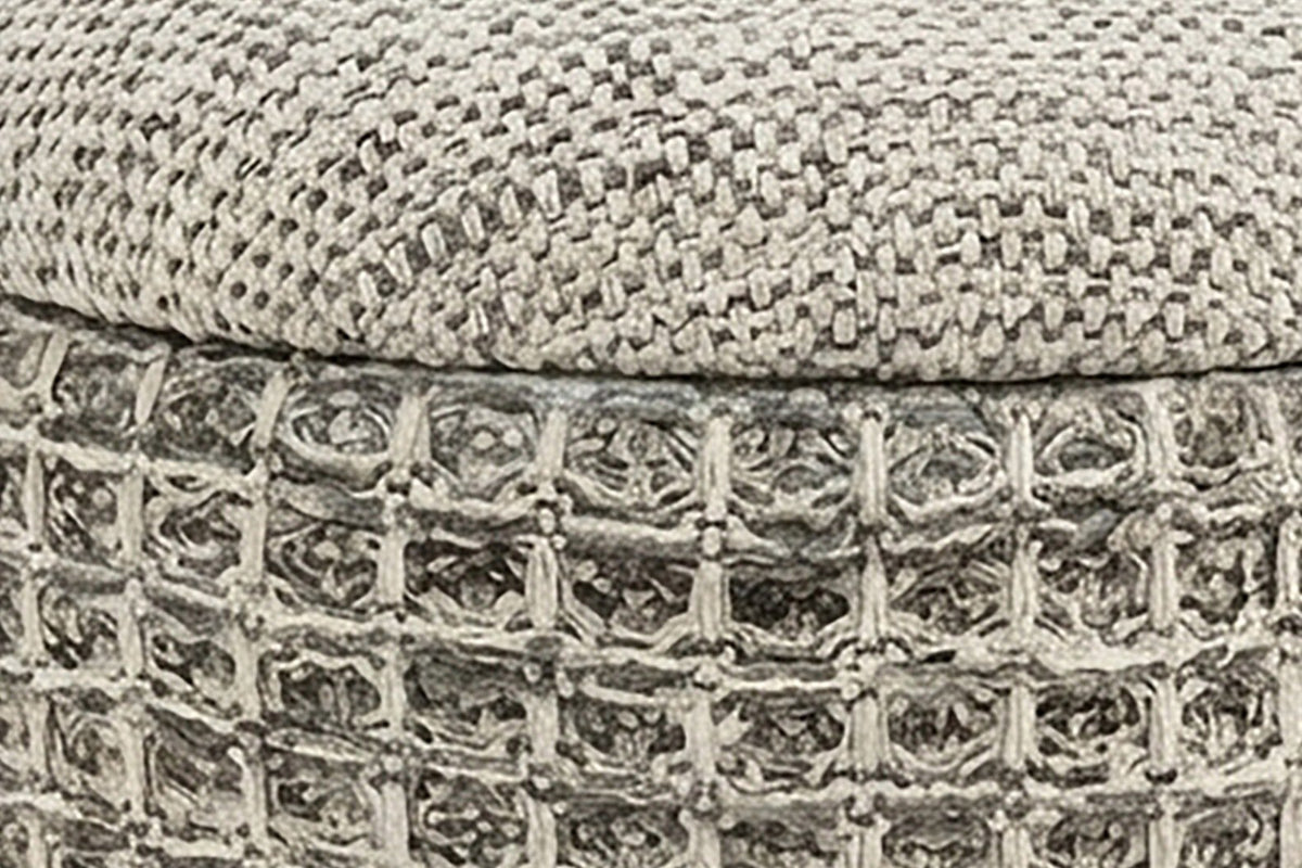 Close-up of the Balme pouf in Charcoal: the domed lid's fine weave over the rolled rim and the square waffle knit