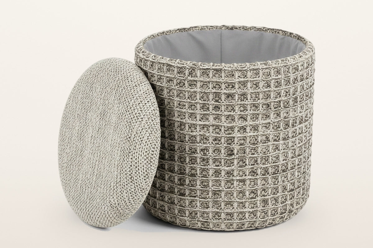 Balme pouf in Charcoal with the lid lifted off and leaning on the drum: storage inside, lined in light grey fabric