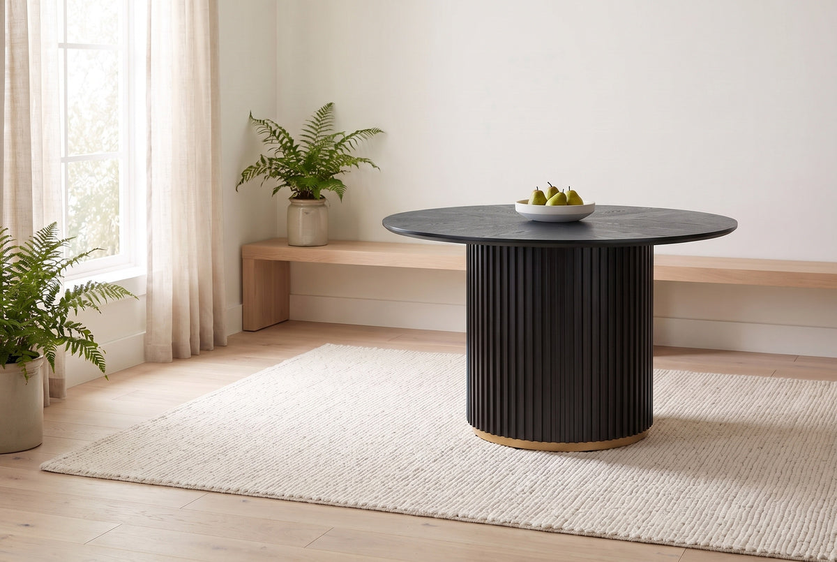 Bardolino round table in black in a bright dining nook, a bowl of pears at the centre, sheer curtains and a pale oak floor