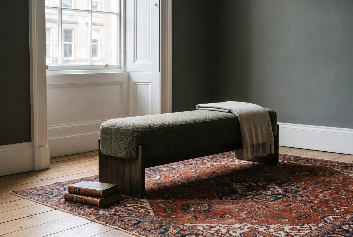 The Bassano bench in dark green loop-yarn boucle on dark rubberwood slab legs on a Persian rug below a sash window, in an Edinburgh townhouse drawing room with deep grey walls and white shutters