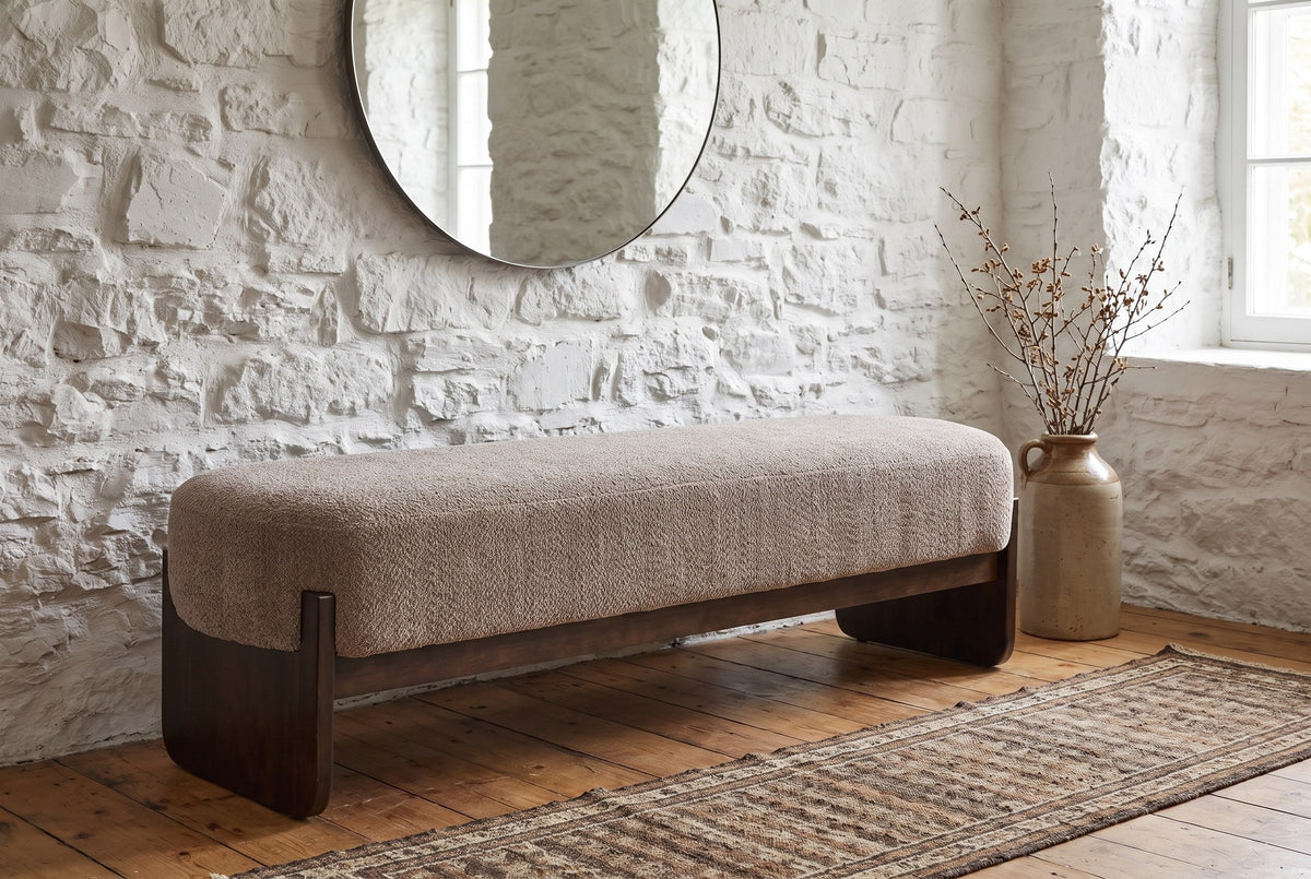 Bassano bench against a whitewashed stone wall in a Quebec City front hall, with a round mirror and a stoneware vase