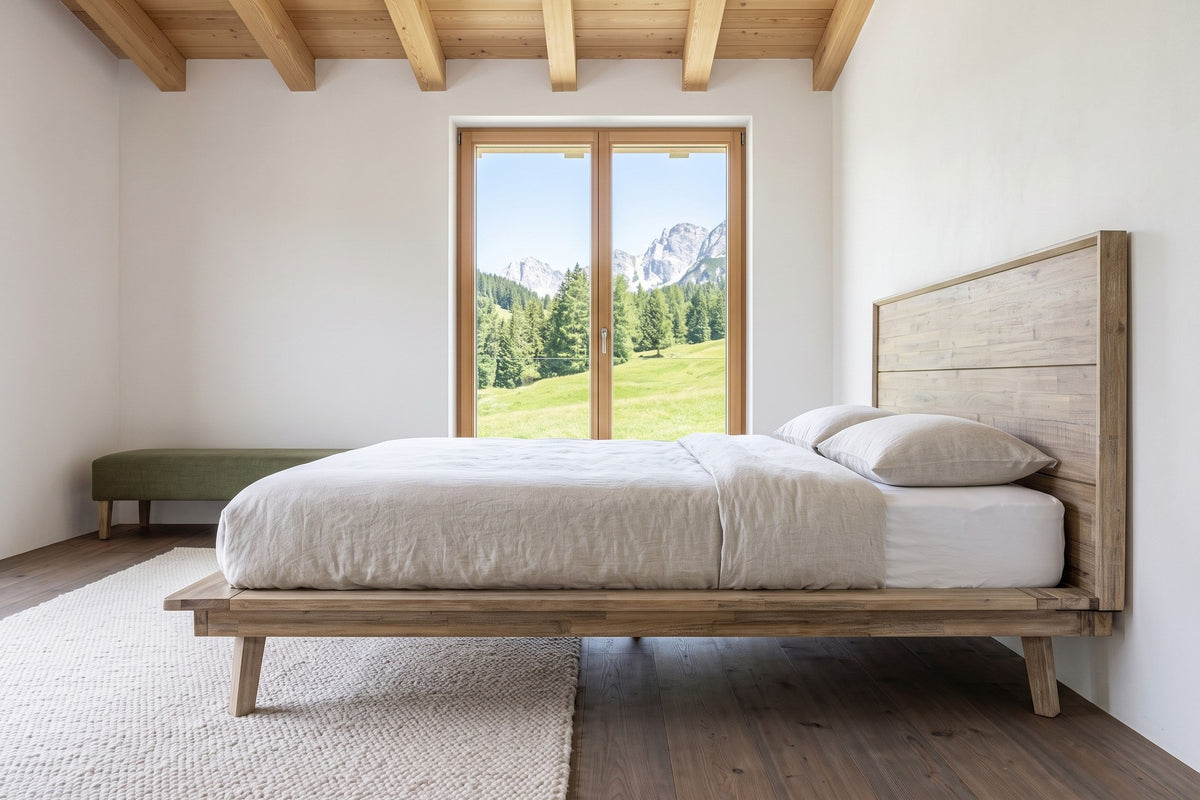 Side view of the Bassiano bed in Light Driftwood in a bedroom in a Lech chalet, with white lime plaster