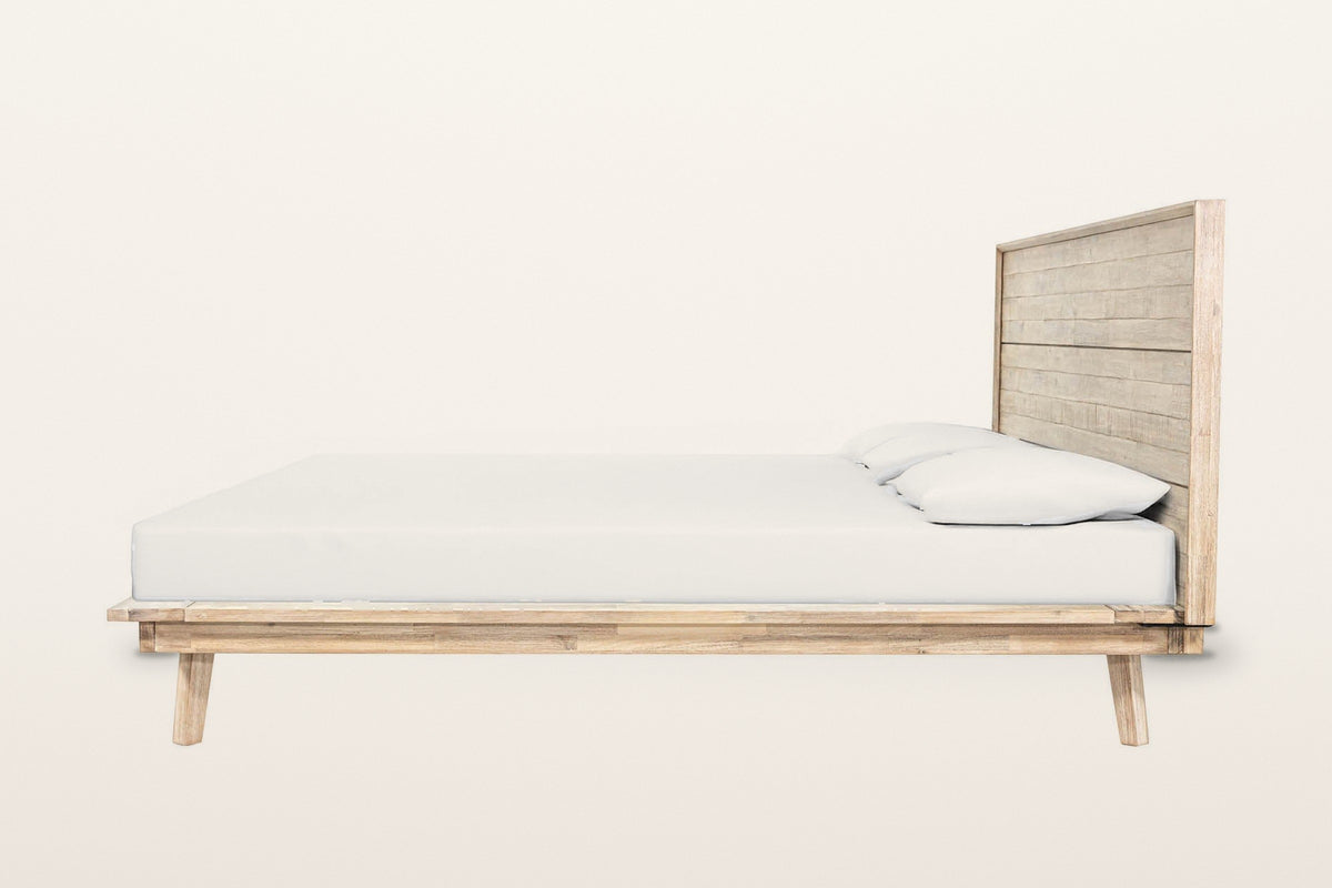 Side view of the Bassiano bed in Light Driftwood on a warm white studio backdrop: the low rim