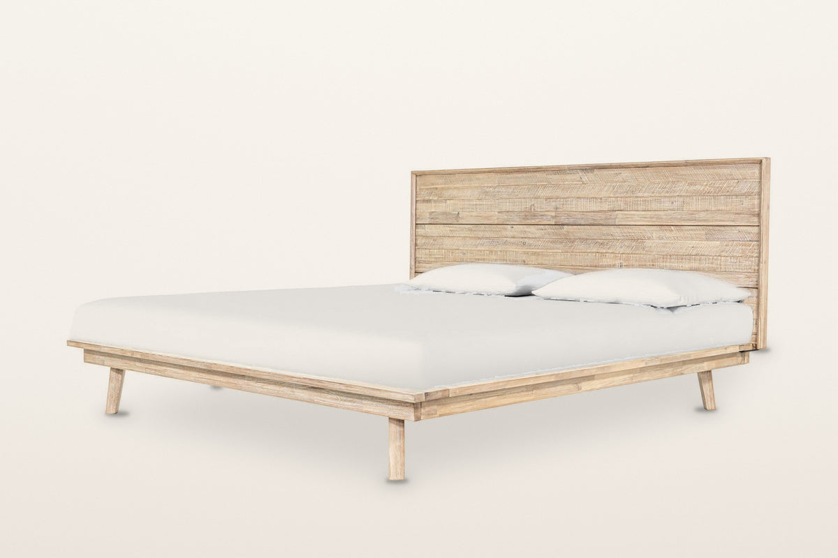 Bassiano bed in Light Driftwood acacia, three-quarter view on a warm white studio backdrop: a low platform with a wide rim