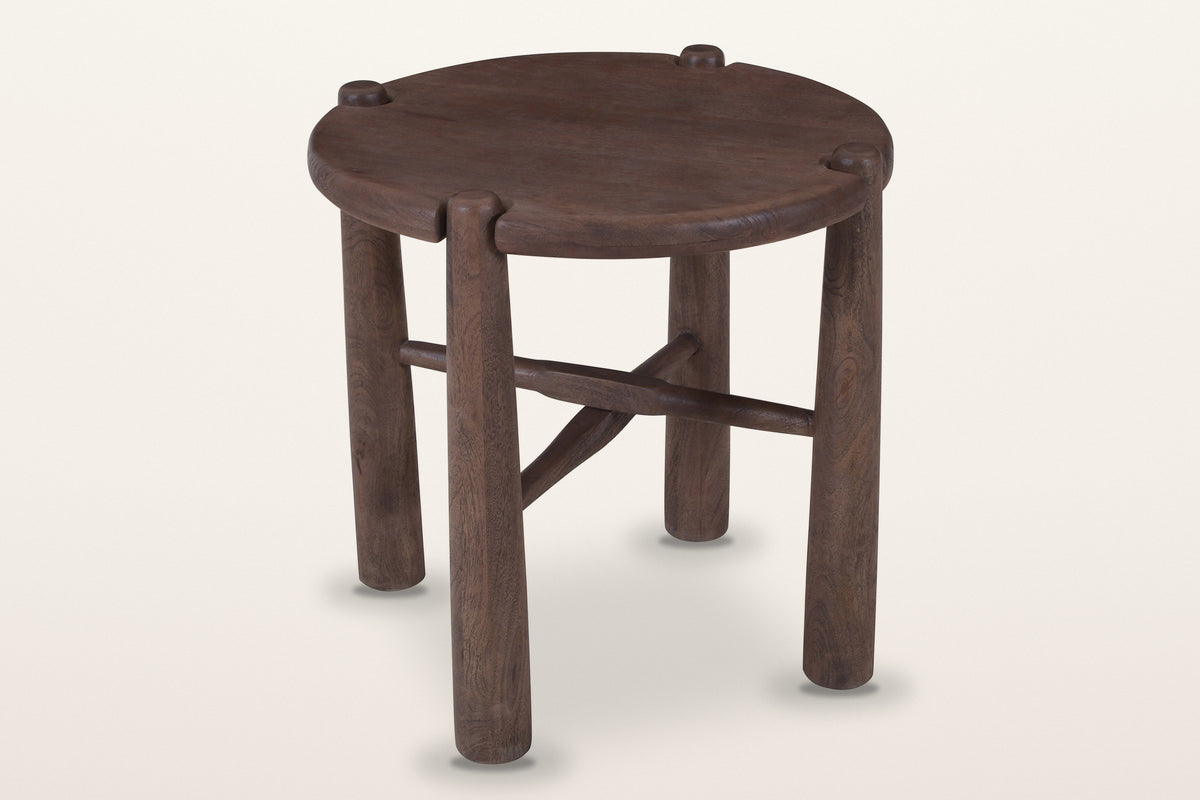 Bettona round side table in solid mango wood, dark walnut finish, three-quarter view on a warm white studio backdrop