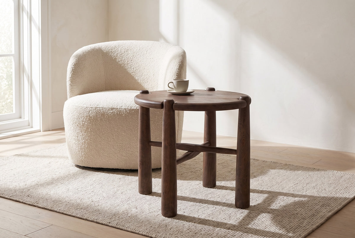 Bettona side table beside a cream boucle armchair in a Toronto living room in morning light, a stoneware cup on top