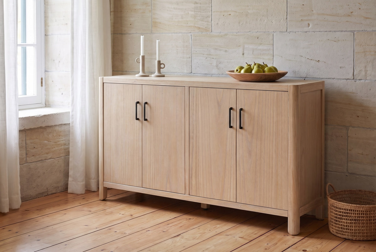 Bibbiena sideboard in Natural against a limestone wall in a dining room with pine floorboards