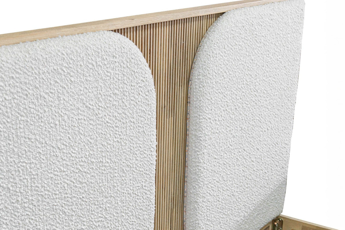 Close-up of the Bienno headboard: two white boucle pads with rounded inner corners and the fluted acacia strip between them