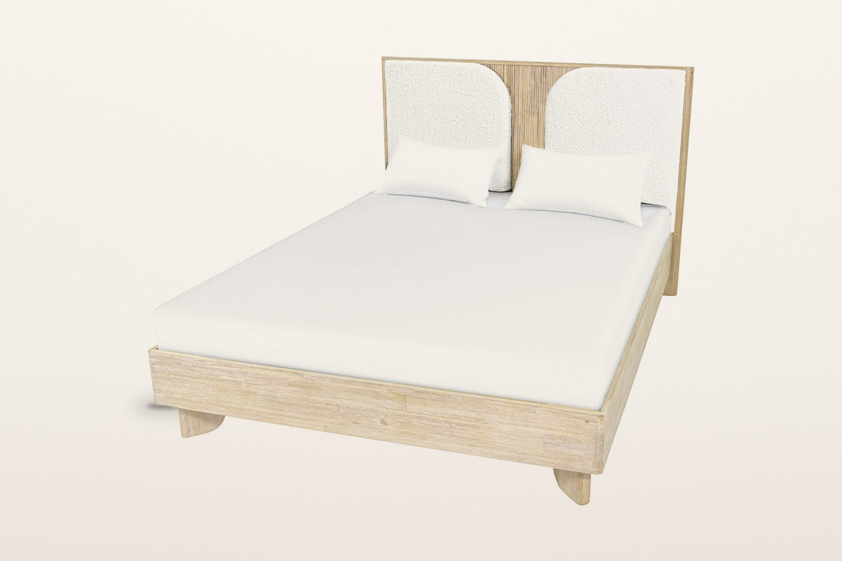 Bienno bed seen from above at the foot on a warm white studio backdrop, with a plain mattress and two pillows