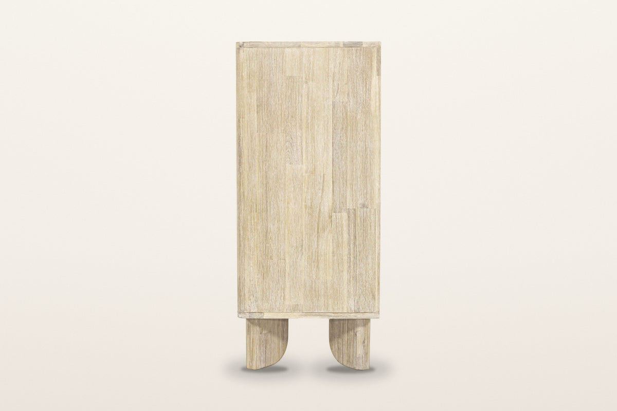 Side view of the Bienno chest in Sand Wash on a warm white studio backdrop: a plain acacia side panel over two flat paddle le