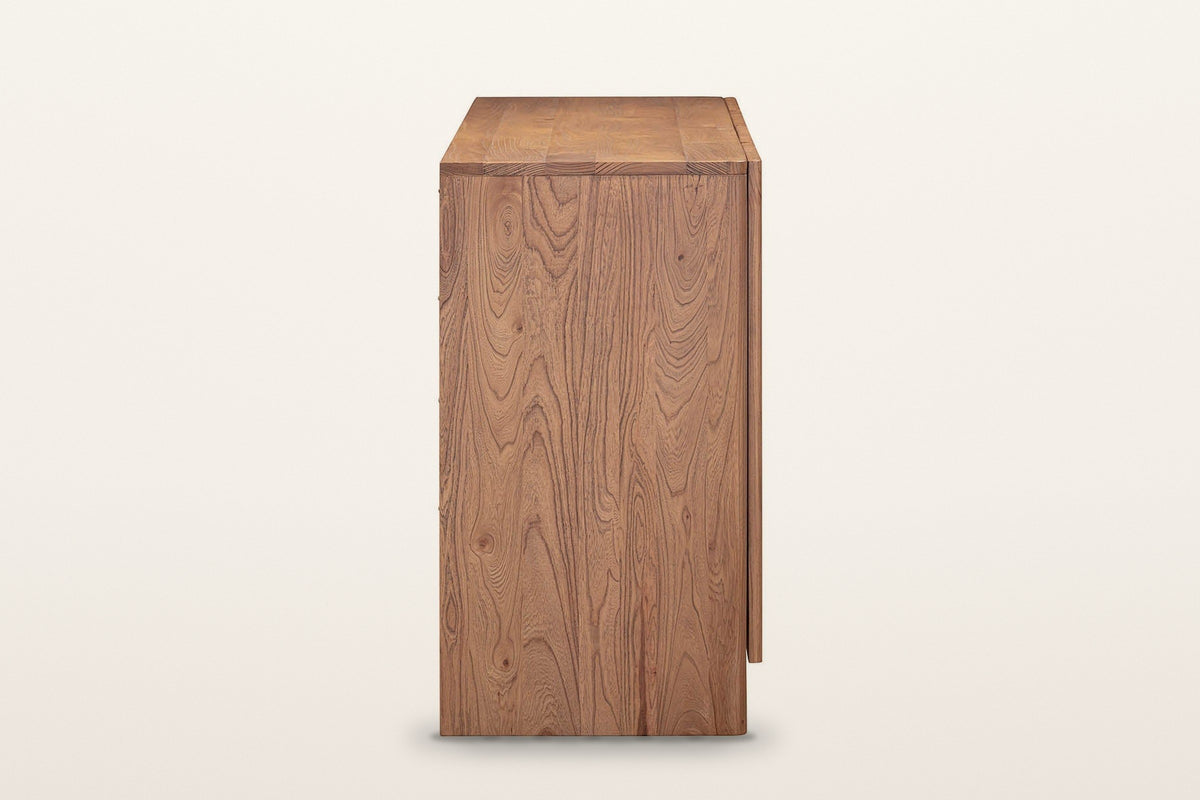 The end of the Bominaco sideboard in Brown on a warm white studio backdrop: a thick end panel down to a block foot