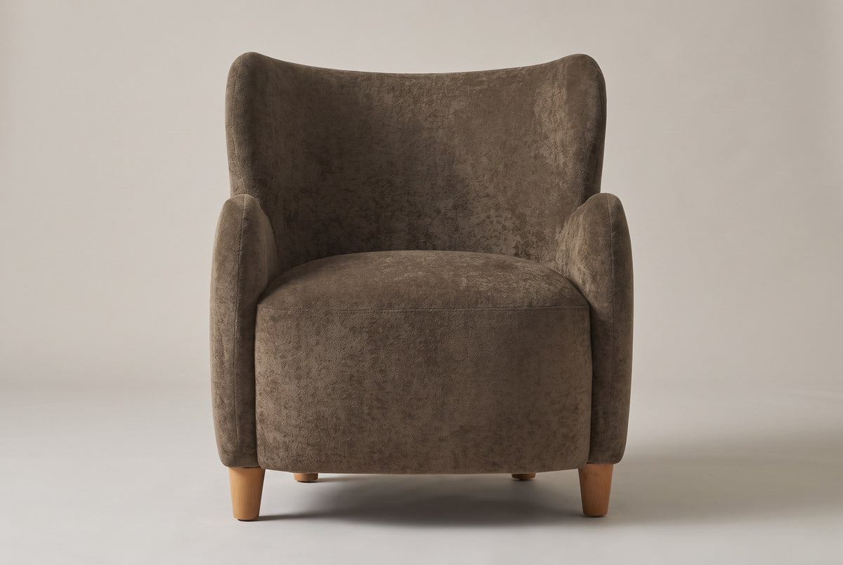 Bormio wingback chair in dark brown velvet, straight front view on a studio backdrop