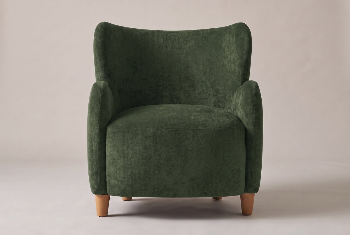 Bormio wingback chair in olive green velvet, straight front view on a studio backdrop