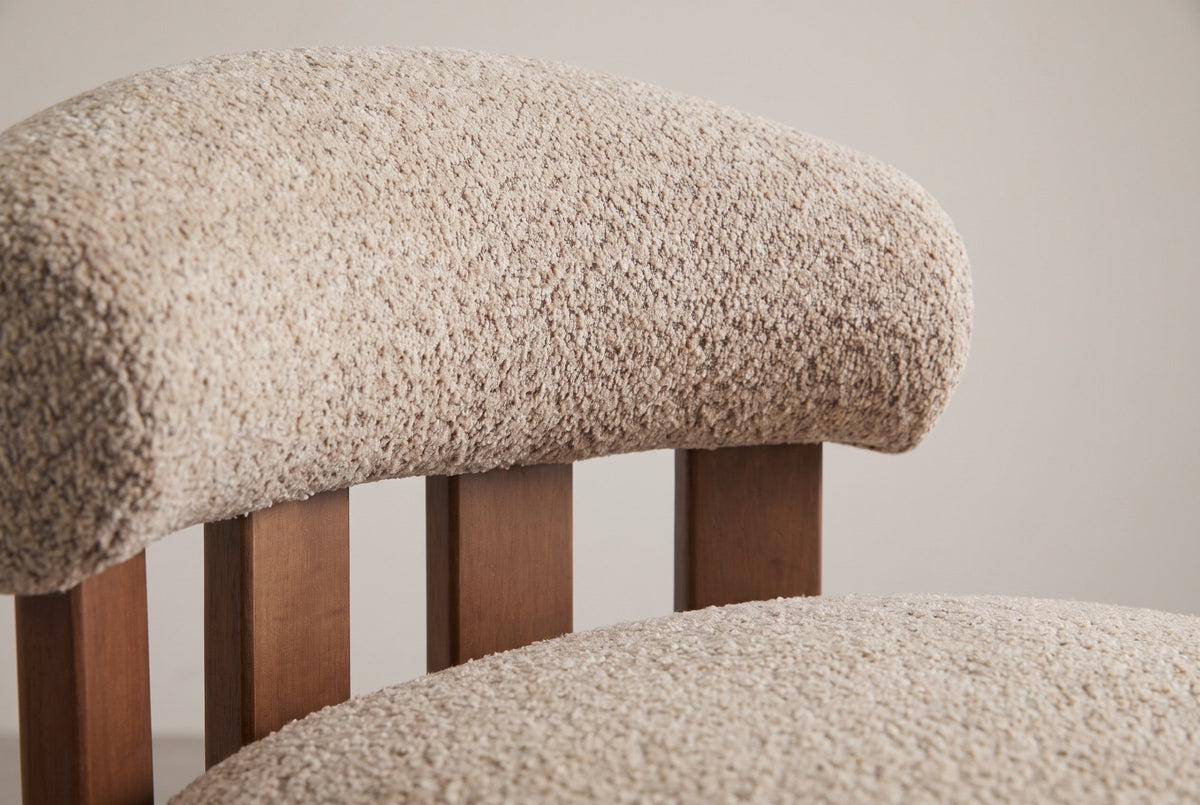 Close-up of the padded Light Brown boucle back roll resting on four walnut-finished birch slats