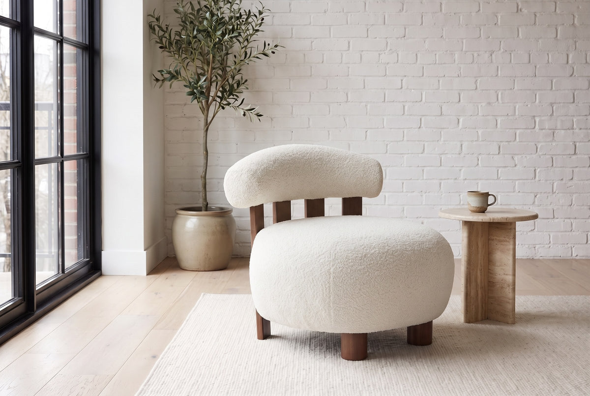Brescia boucle accent chair in a white-brick loft with a travertine side table