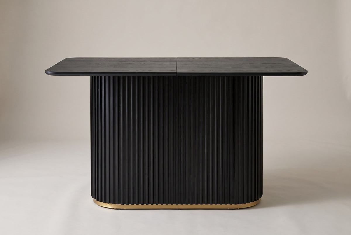 Brugnato counter height table in black, front view: a two-piece top with a centre seam on one fluted pedestal with a gold rin