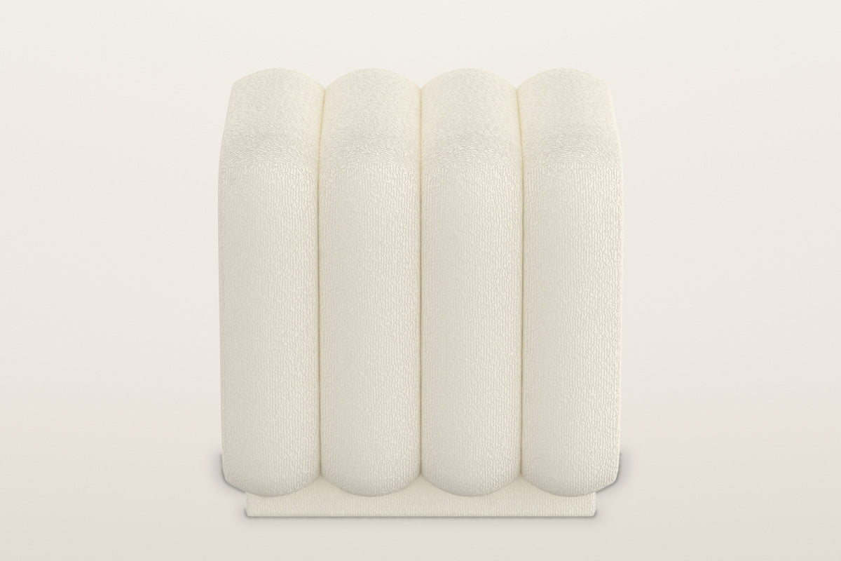 Brusson ottoman straight on: four equal rounded channels in cream boucle over the recessed plinth