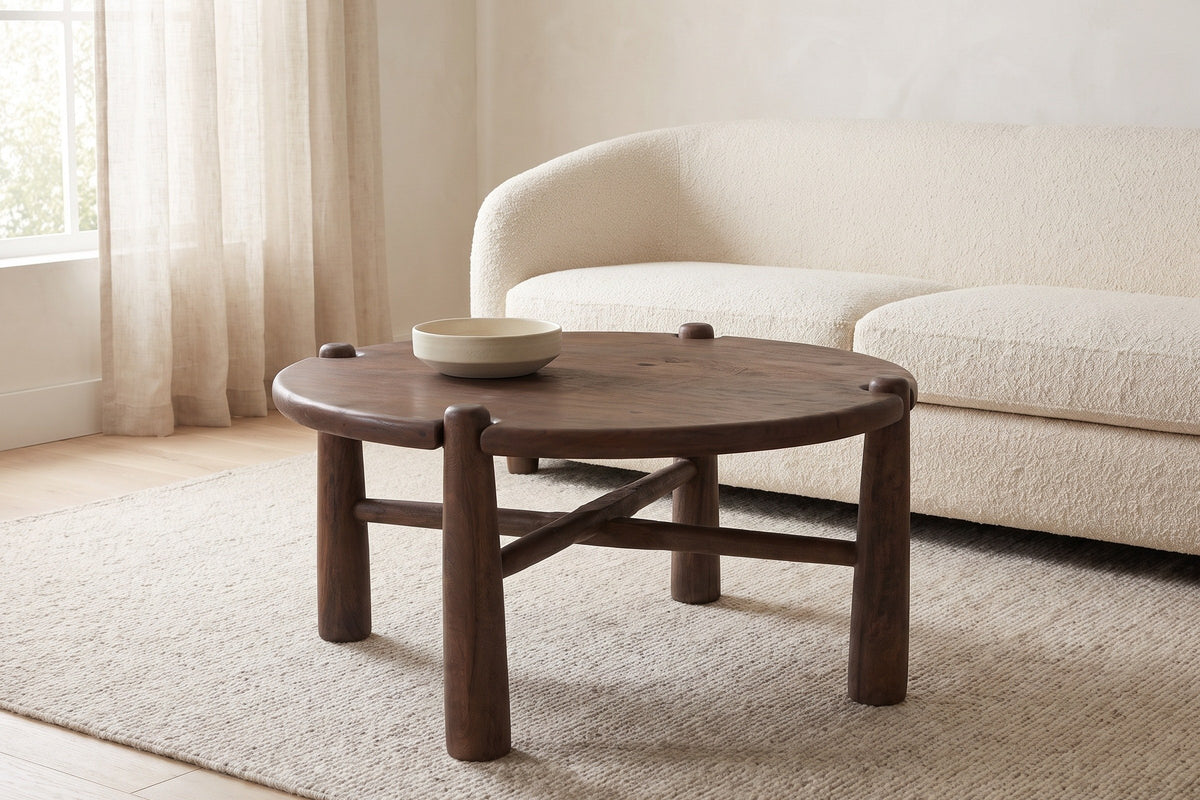 Buonconvento coffee table in dark walnut on an oatmeal wool rug in front of a cream boucle sofa in a bright Vancouver living