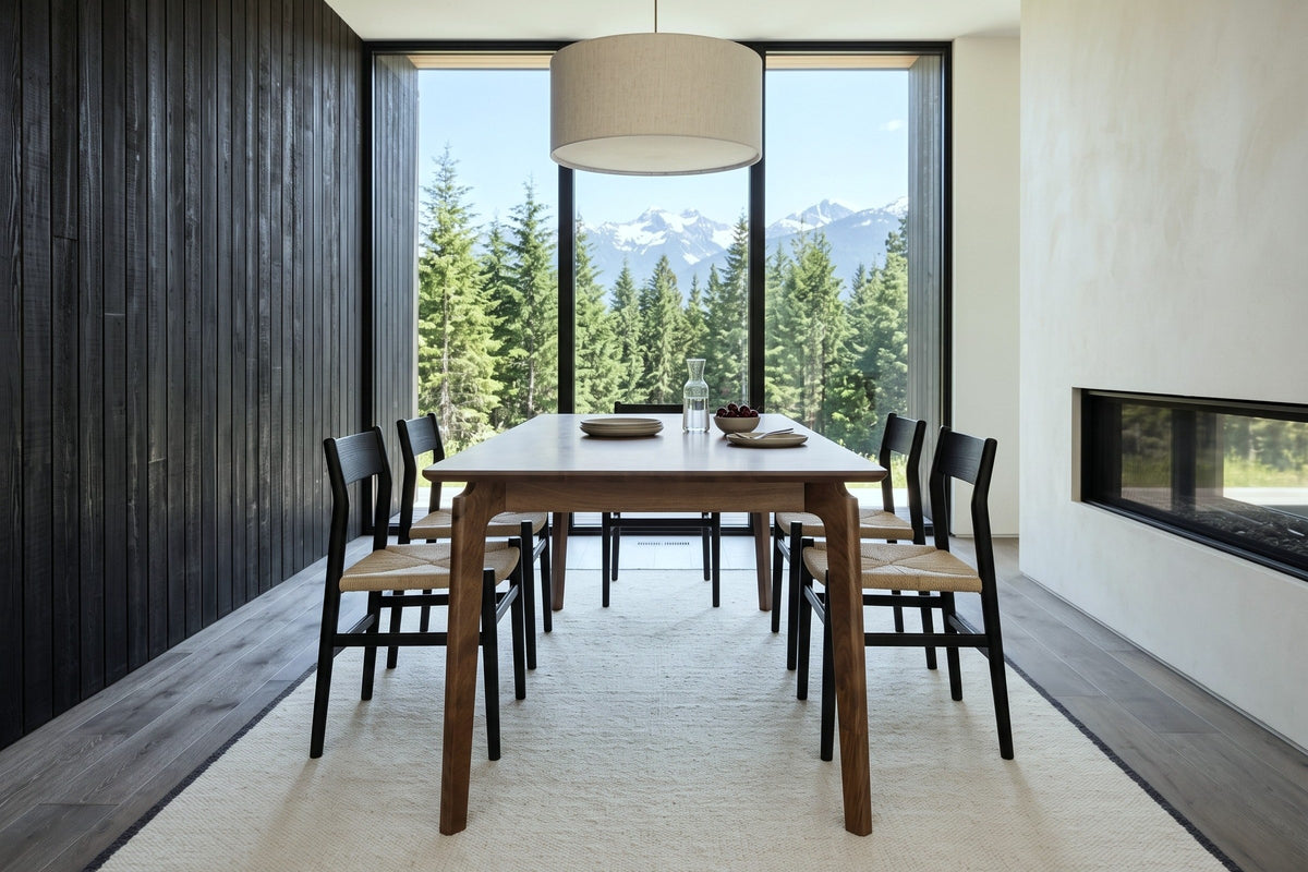End view of the Calascio dining table in Brown in a Revelstoke mountain house, with a black cedar board wall