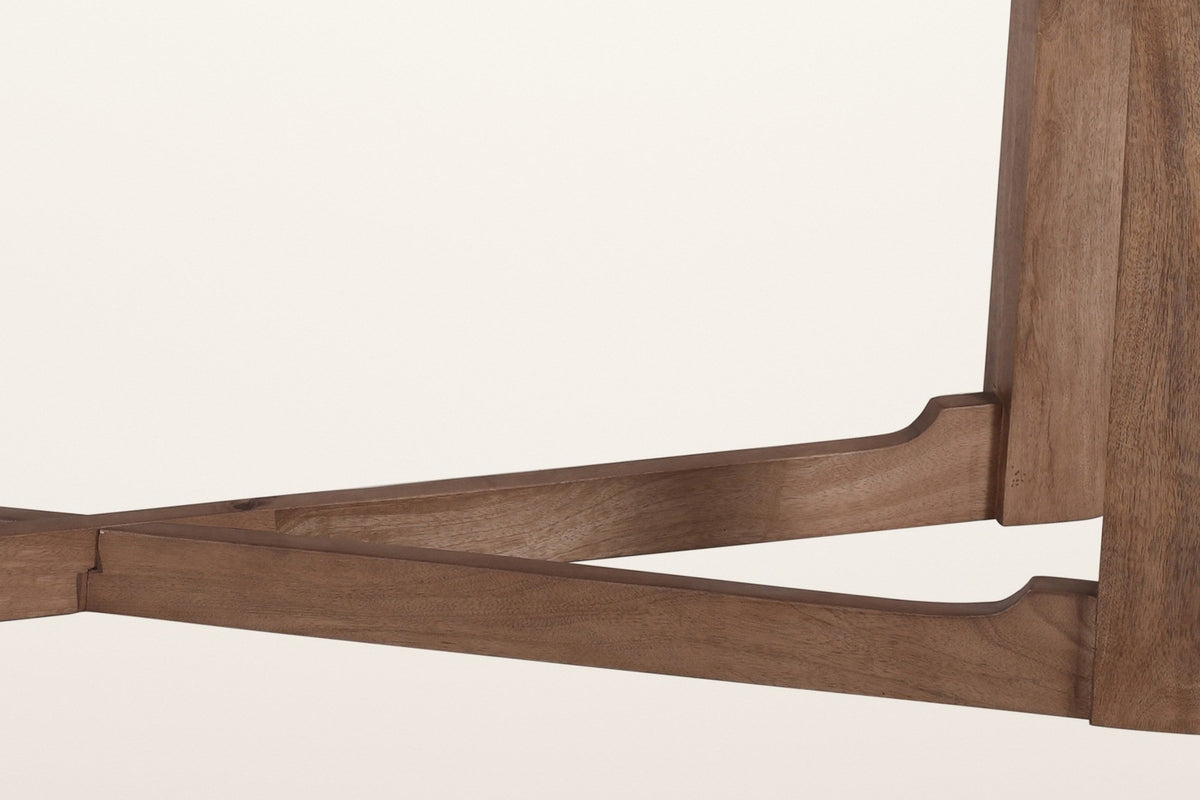 Close-up of the Calcata base: a stretcher arm stepping up in a small cove to meet a walnut plank leg