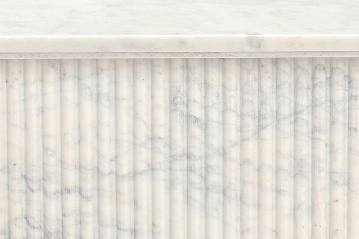 Close-up of the Campiglia pedestal: narrow rounded marble reeds under the edge of the top and its set-back plate