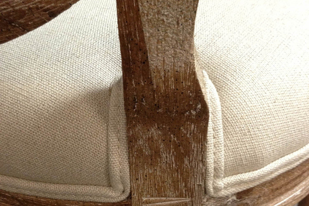 Close-up of a Candelo back post meeting the linen seat, the brown-washed oak grain showing