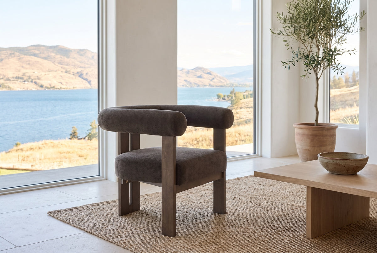 Caorle chair on a jute rug in a Kelowna lake house with tall windows onto the lake and hills