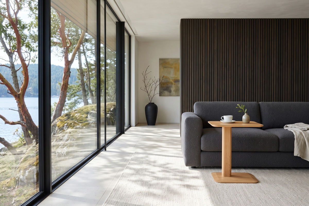 Capalbio side table in Natural at the arm of a charcoal boucle sofa in a Maple Bay house on Vancouver Island