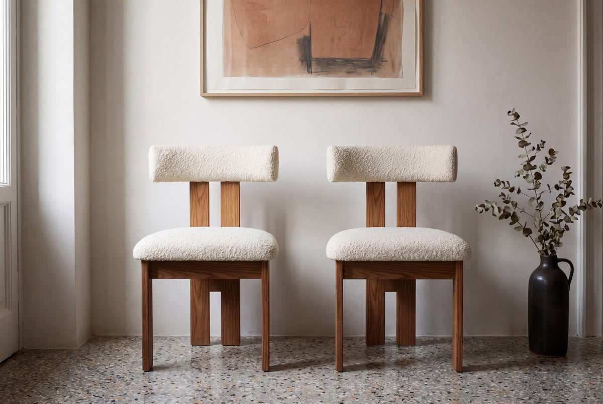 Two Carlo dining chairs seen straight on against a plaster wall