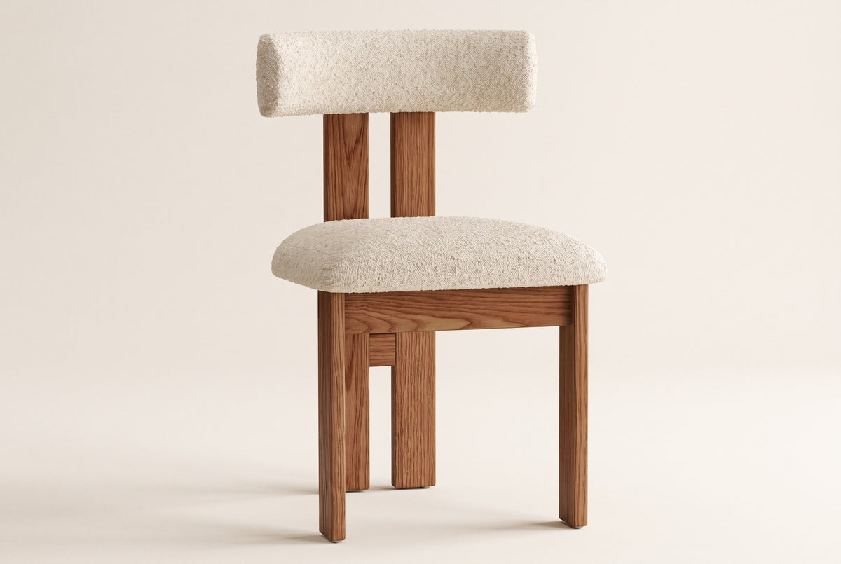 A single Carlo dining chair seen from a front three-quarter angle on an off-white studio backdrop: the ivory boucle bolster on two wire-brushed oak back planks, the padded boucle seat and the square oak legs