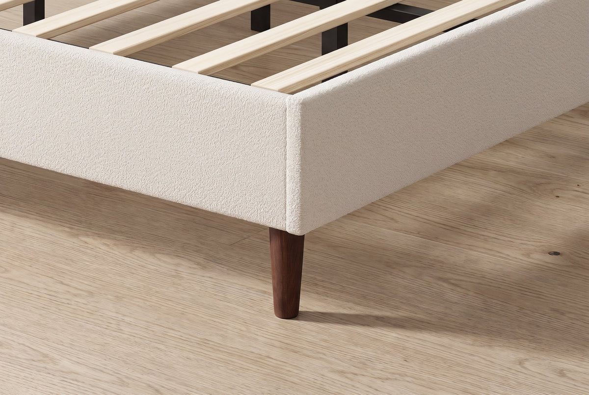 Close-up of the Carrara rail corner in beige chenille on a tapered dark wood leg, with the slats inside