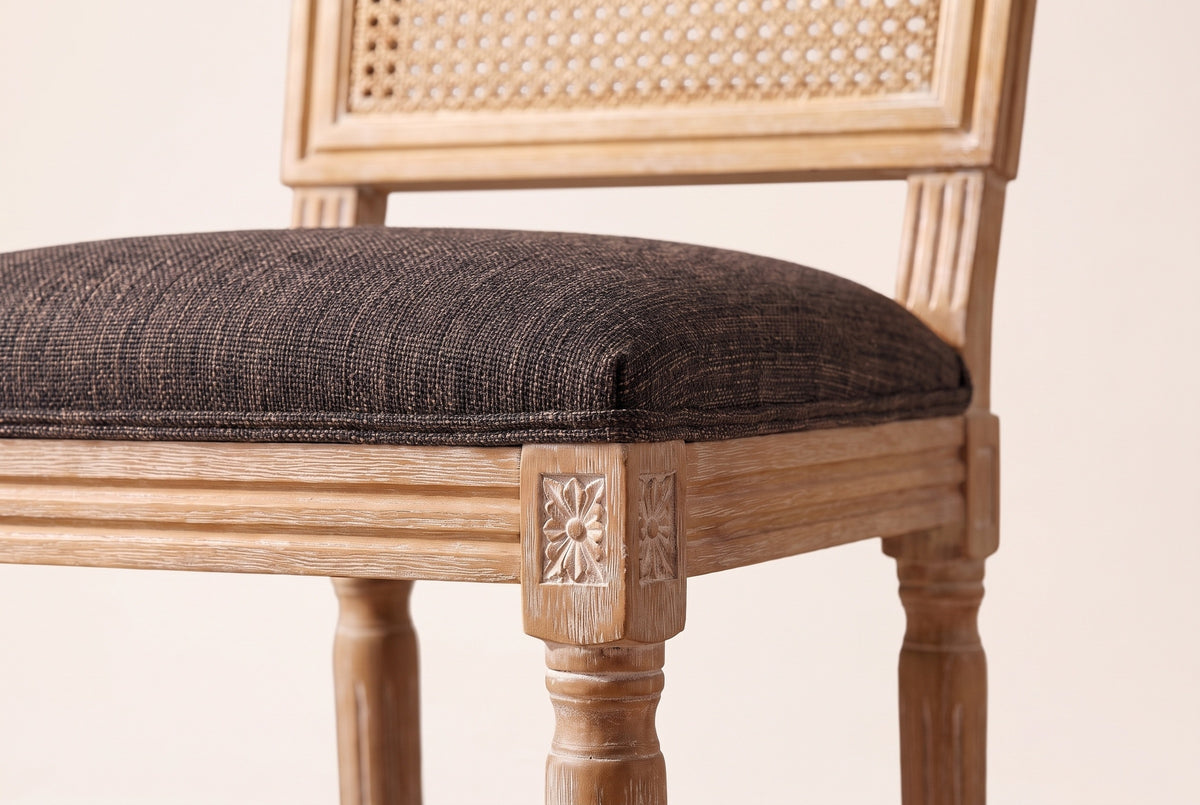 Close-up of the Brown linen-look seat, the reeded rail and the carved rosette on a front corner block