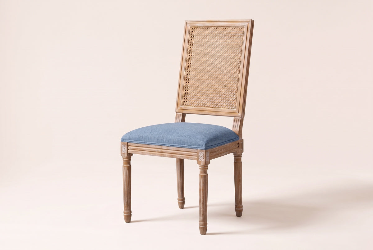 Castelfranco French cane-back dining chair in Denim Blue, three-quarter view on a warm off-white backdrop