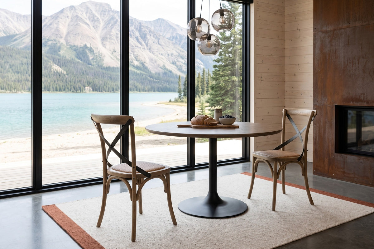 Two Castelmola dining chairs in Natural Rustic at a round table on a black base in a Carcross house, with spruce boards