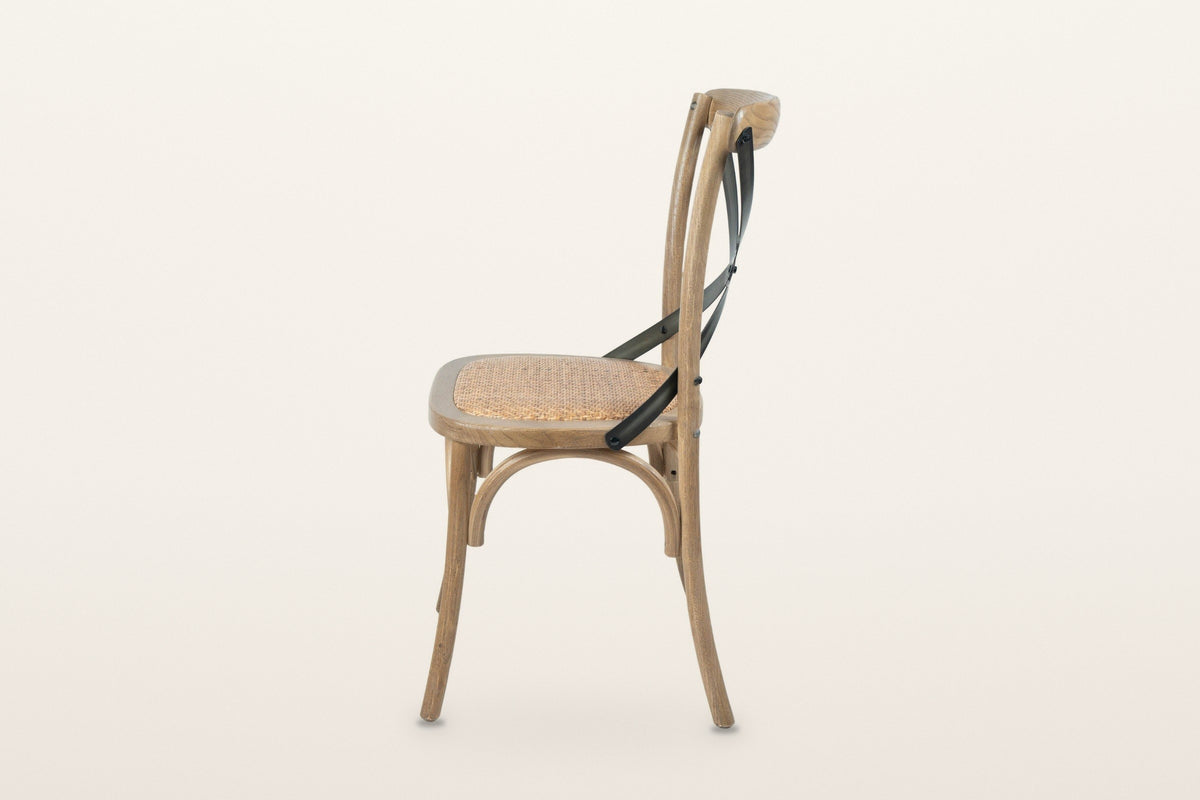 Castelmola dining chair in Natural Rustic, side view on a warm white studio backdrop