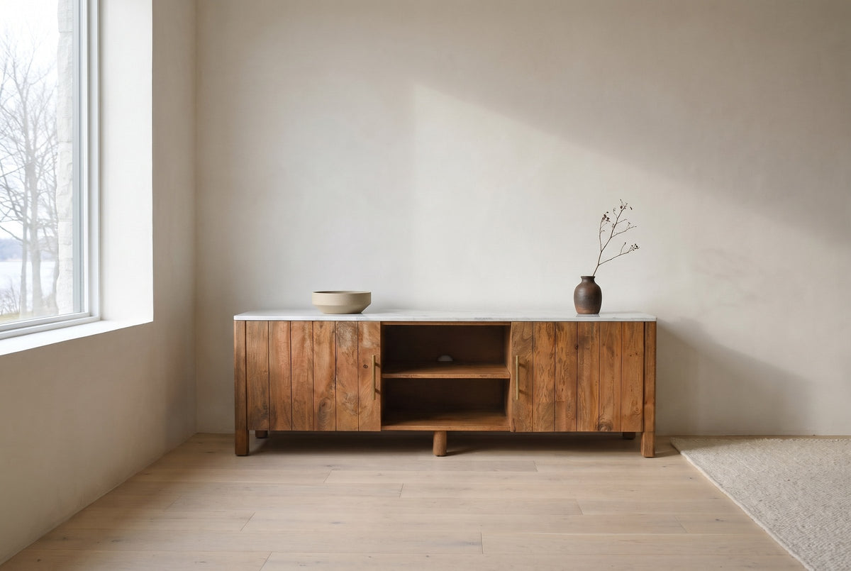 Ceresole mango wood media cabinet with a white marble top against a limewash wall in a Kingston, Ontario living room, bare trees through the window