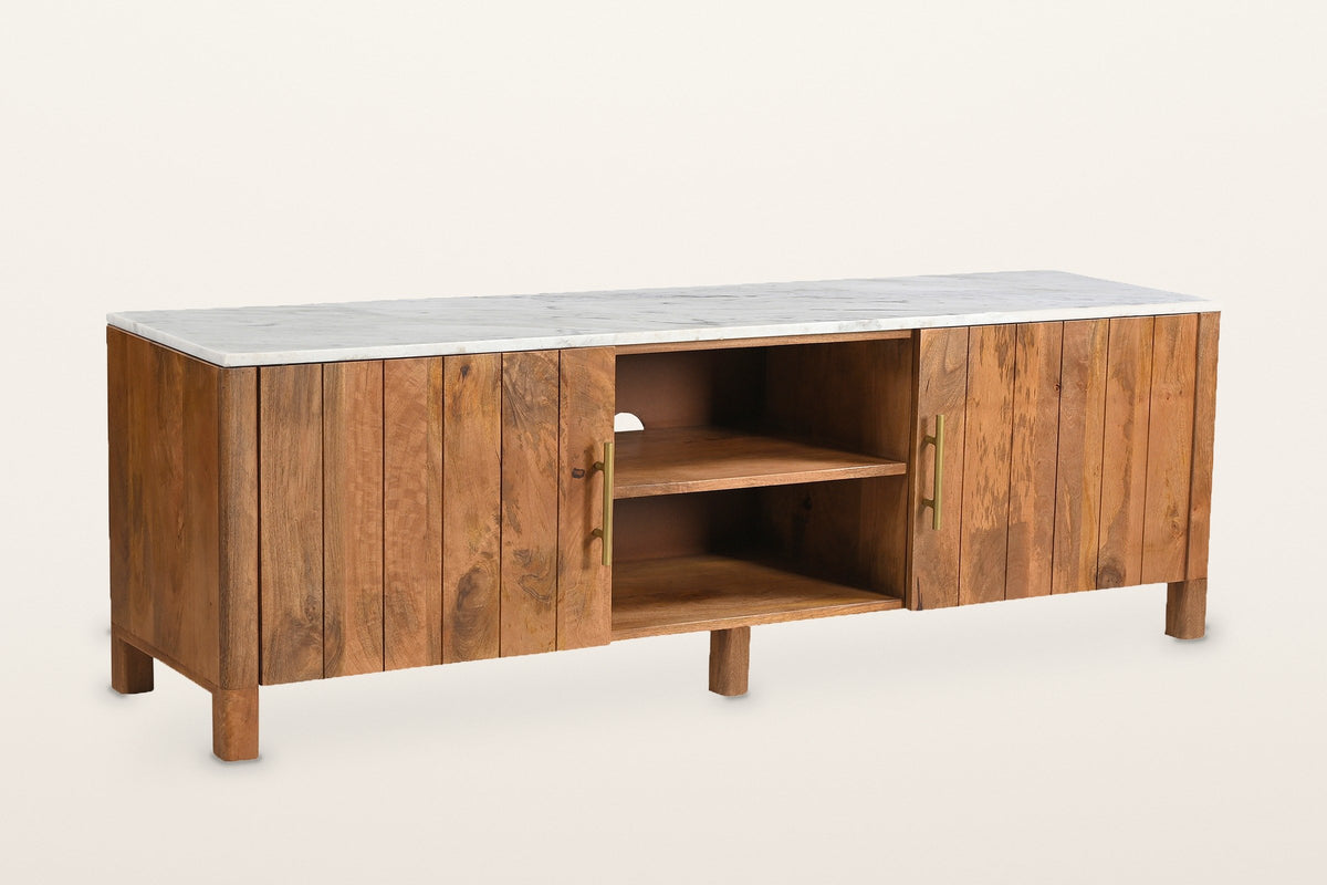 Ceresole 63 in media cabinet in mango wood with a white marble top: two plank doors with aged-gold bar pulls either side of an open centre with one shelf, on round legs, three-quarter view on a warm white studio backdrop