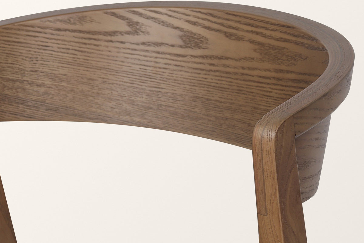 Close-up of the Certosa back band in walnut: ash grain, the layered bent-plywood edge and the rear leg meeting the band
