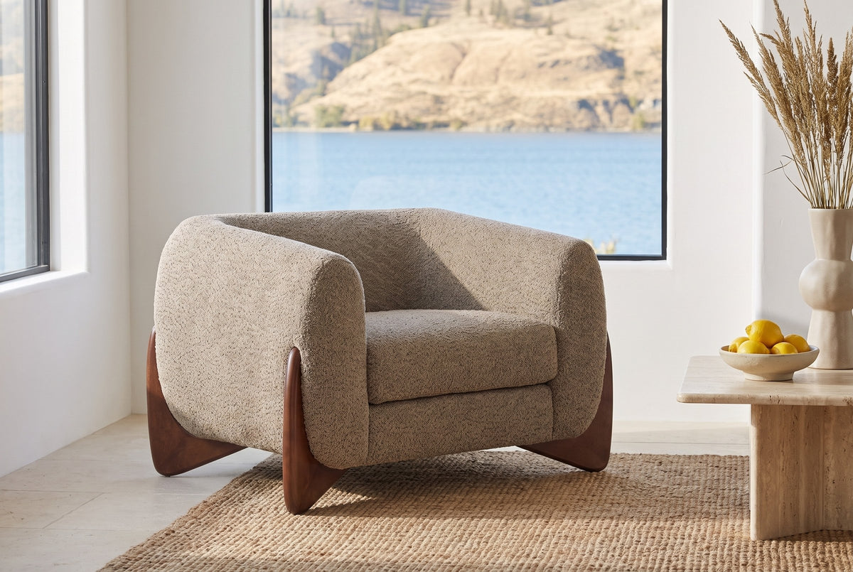 Cervia lounge chair on a jute rug in a Kelowna lake house with a window onto the lake and hills